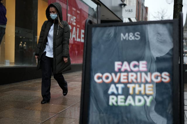 <p>People wear face masks as they shop in the rain in Preston </p>