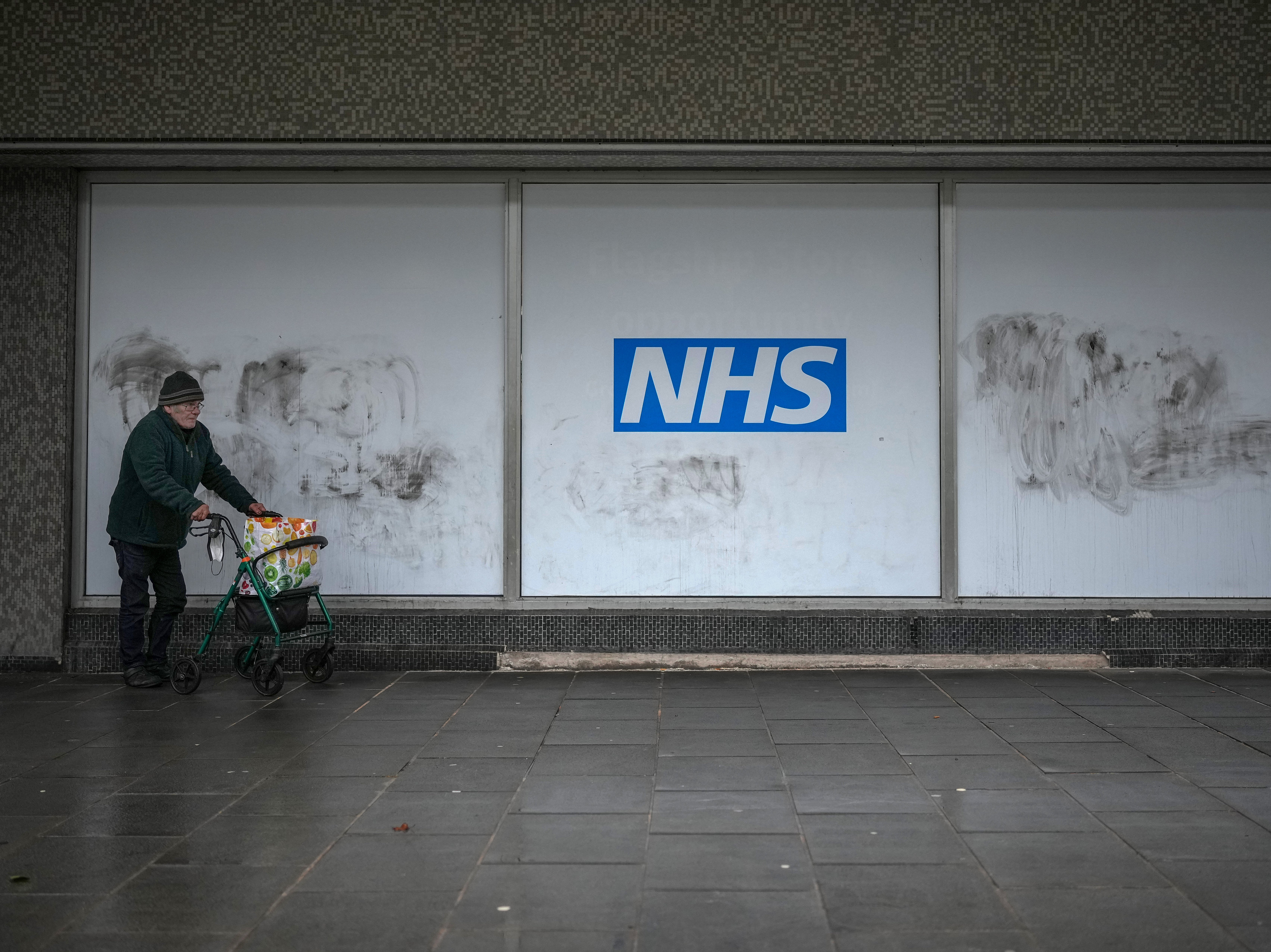 A man walks past NHS signage near a Covid vaccine centre in Preston on Thursday