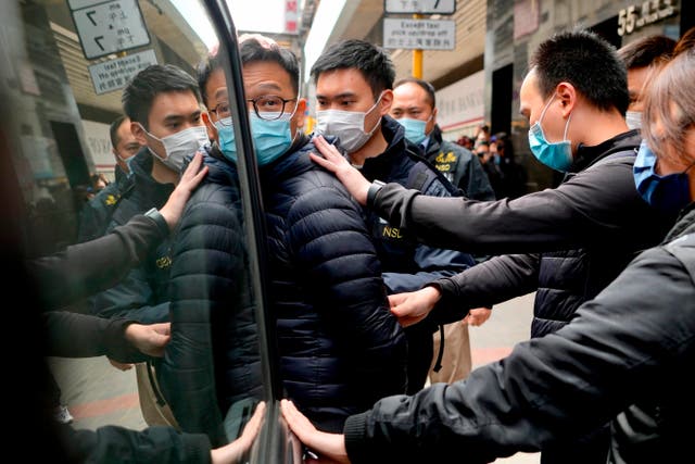 <p>Editor of Stand News' Patrick Lam, center, is escorted by police officers into a van after they searched his office in Hong Kong on Wednesday</p>