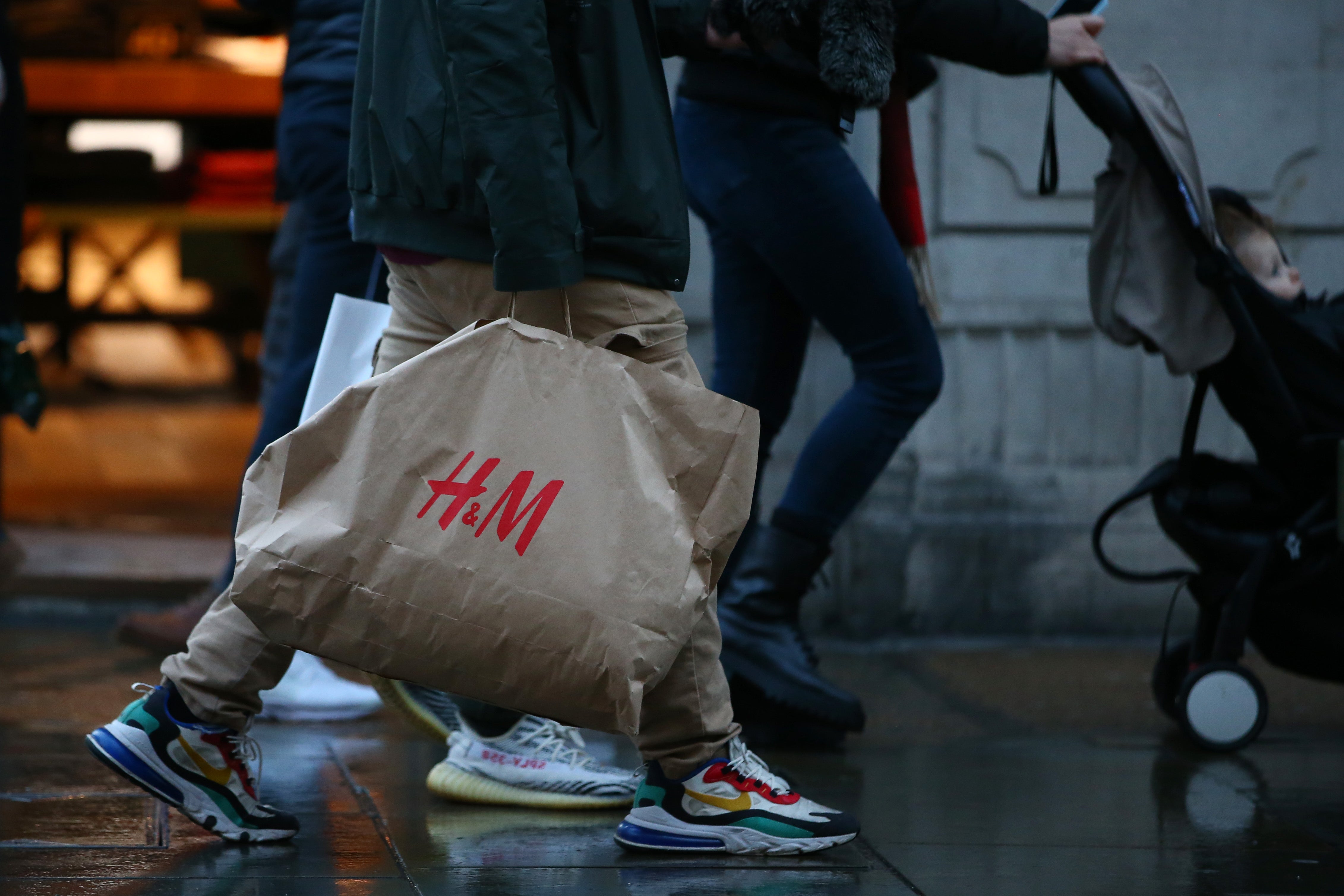 Shoppers carrying a H&M bag walk along Regent Street in London