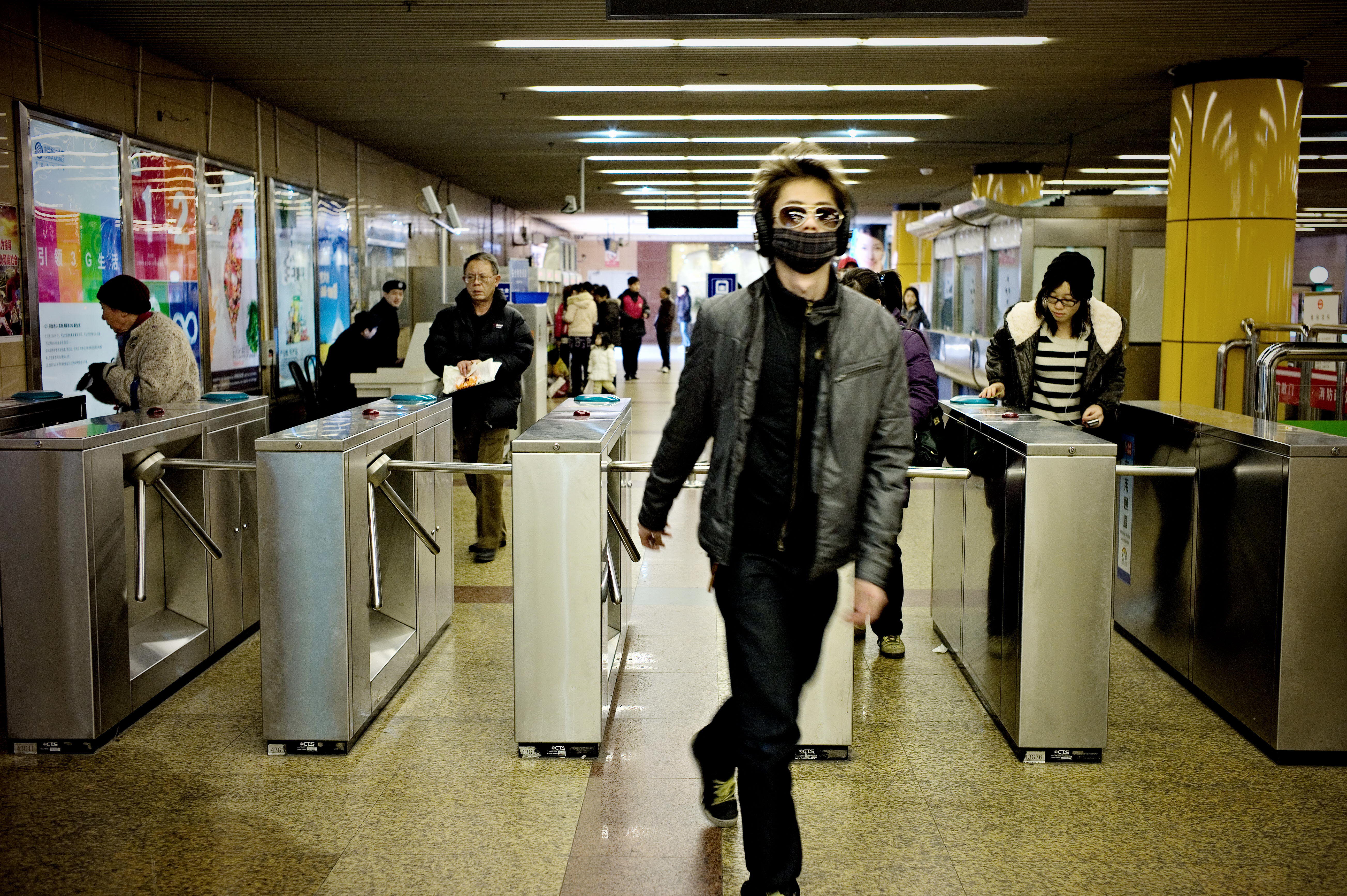 Passengers enter a metro station in Shanghai