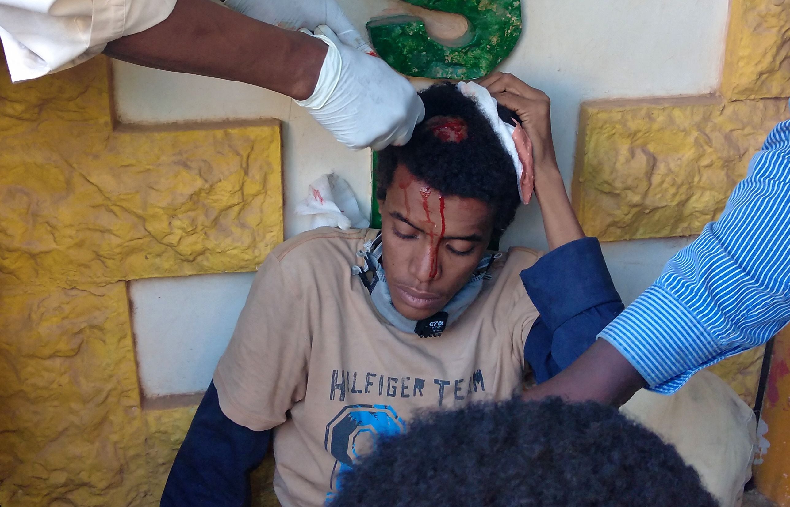 People tend to the wounds of a fellow protester in Khartoum