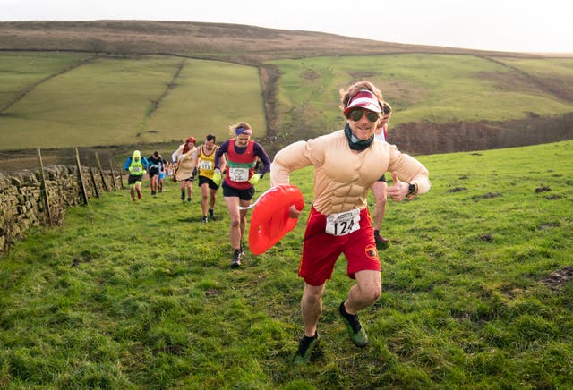 Competitors in fancy dress run across the Pennine tops near Haworth, West Yorkshire, in the annual Auld Lang Syne Fell race which attracts hundreds of runners every year