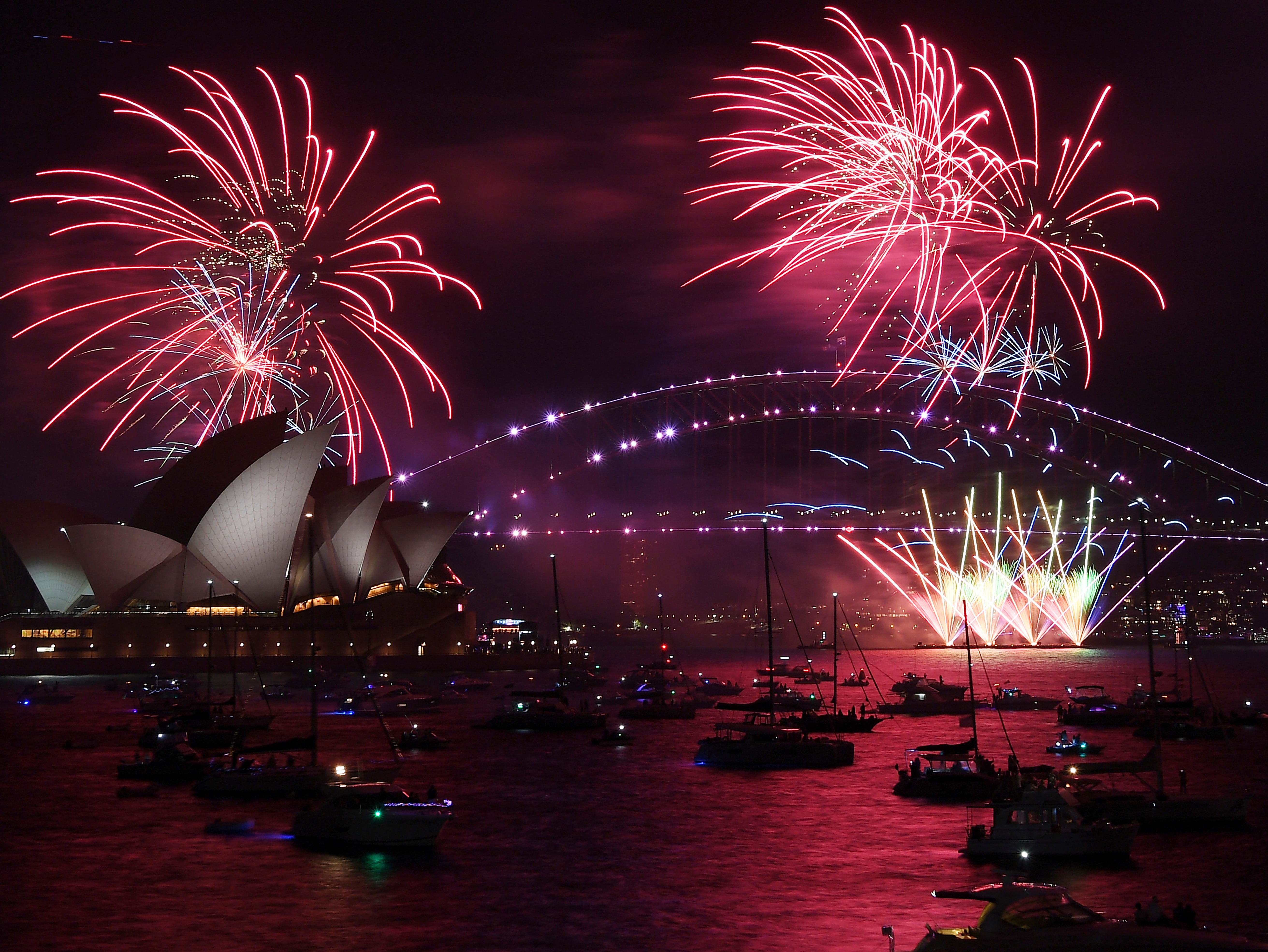 Fireworks explode over the Sydney Opera House and Harbour Bridge as New Year's Eve celebrations begin in Sydney