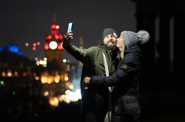 Arthur Grace and Lynsey Gray, from Fife, take a selfie on Edinburgh’s Calton Hill ahead of the bells on New Year’s Eve (Jane Barlow/PA)