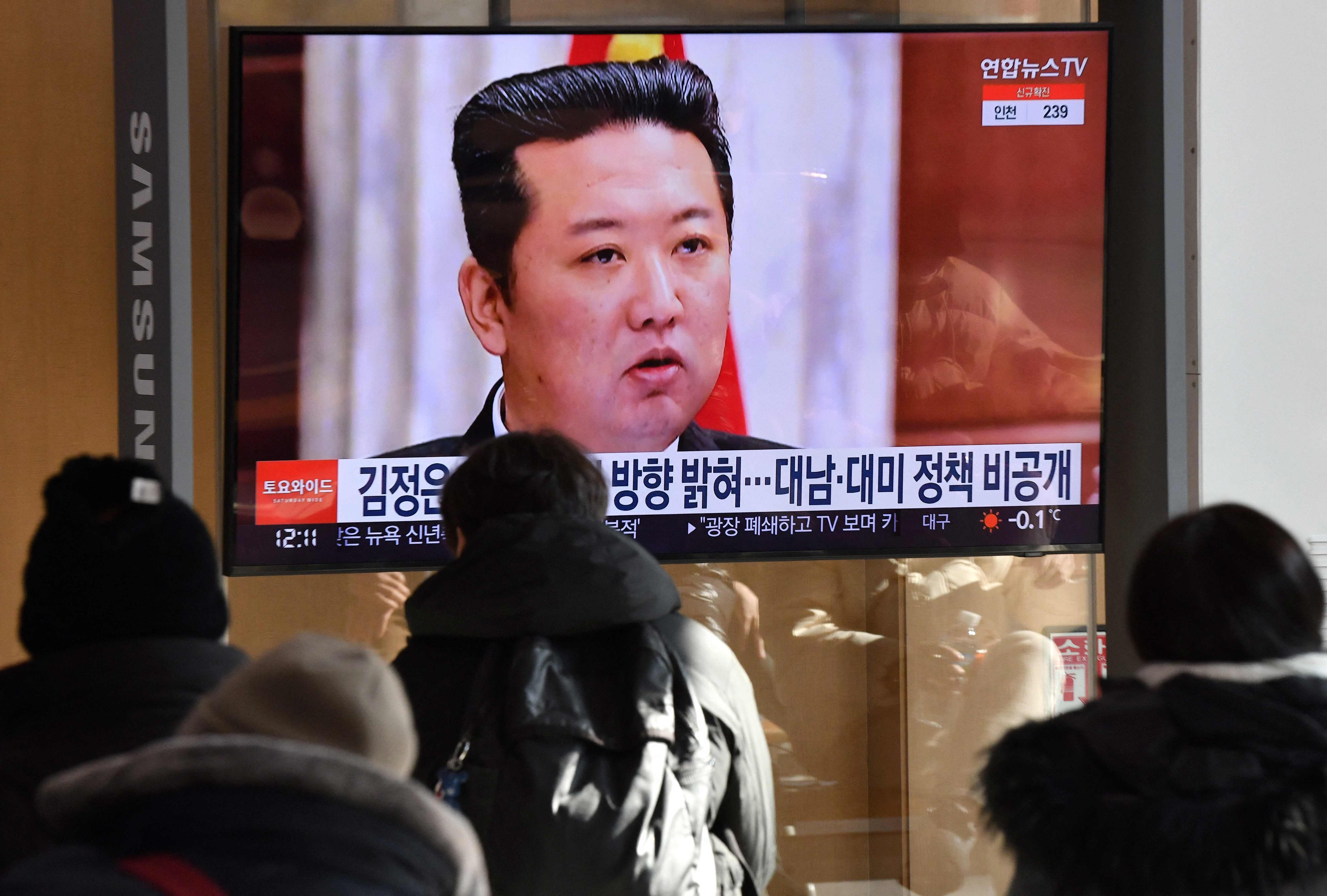 People watch a television news programme showing a picture of North Korean leader Kim Jong-un attending a plenary meeting of the Central Committee of the Workers’ Party of Korea on 1 January