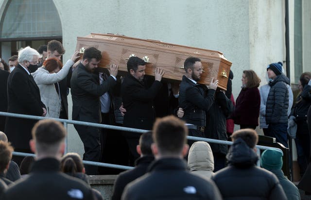 Family members hold onto the coffin of Nathan Corrigan, 20, as it is carried from St Matthew’s Church (Oliver McVeigh/PA)