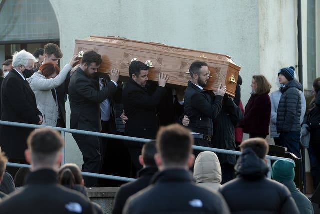 Family members hold onto the coffin of Nathan Corrigan, 20, as it is carried from St Matthew’s Church (Oliver McVeigh/PA)