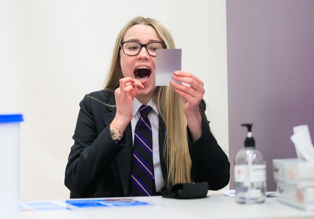 Erin Horn looking in a mirror while taking a Lateral Flow Test as children arrive at Outwood Academy in Woodlands, Doncaster in Yorkshire (Danny Lawson/PA)