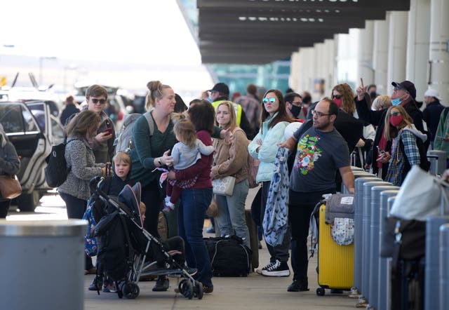 <p>Travelers queue up at the Southwest Airlines curbside check-in area at Denver International Airport on 26 December</p>