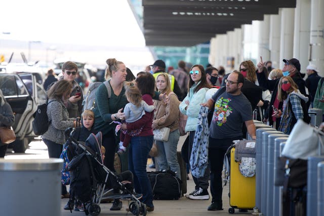 <p>Travelers queue up at the Southwest Airlines curbside check-in area at Denver International Airport on 26 December</p>