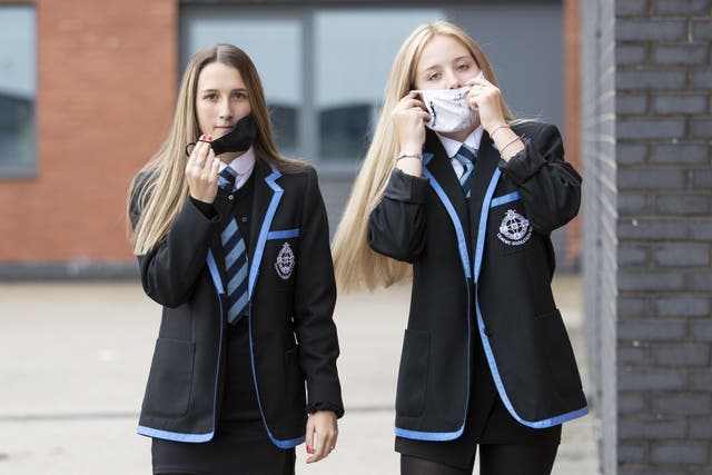 Leah McCallum (left) and Rebecca Ross, S4 students at St Columba’s High School, Gourock, put on their protective face masks as the requirement for secondary school pupils to wear face coverings when moving around school comes into effect from today across Scotland.