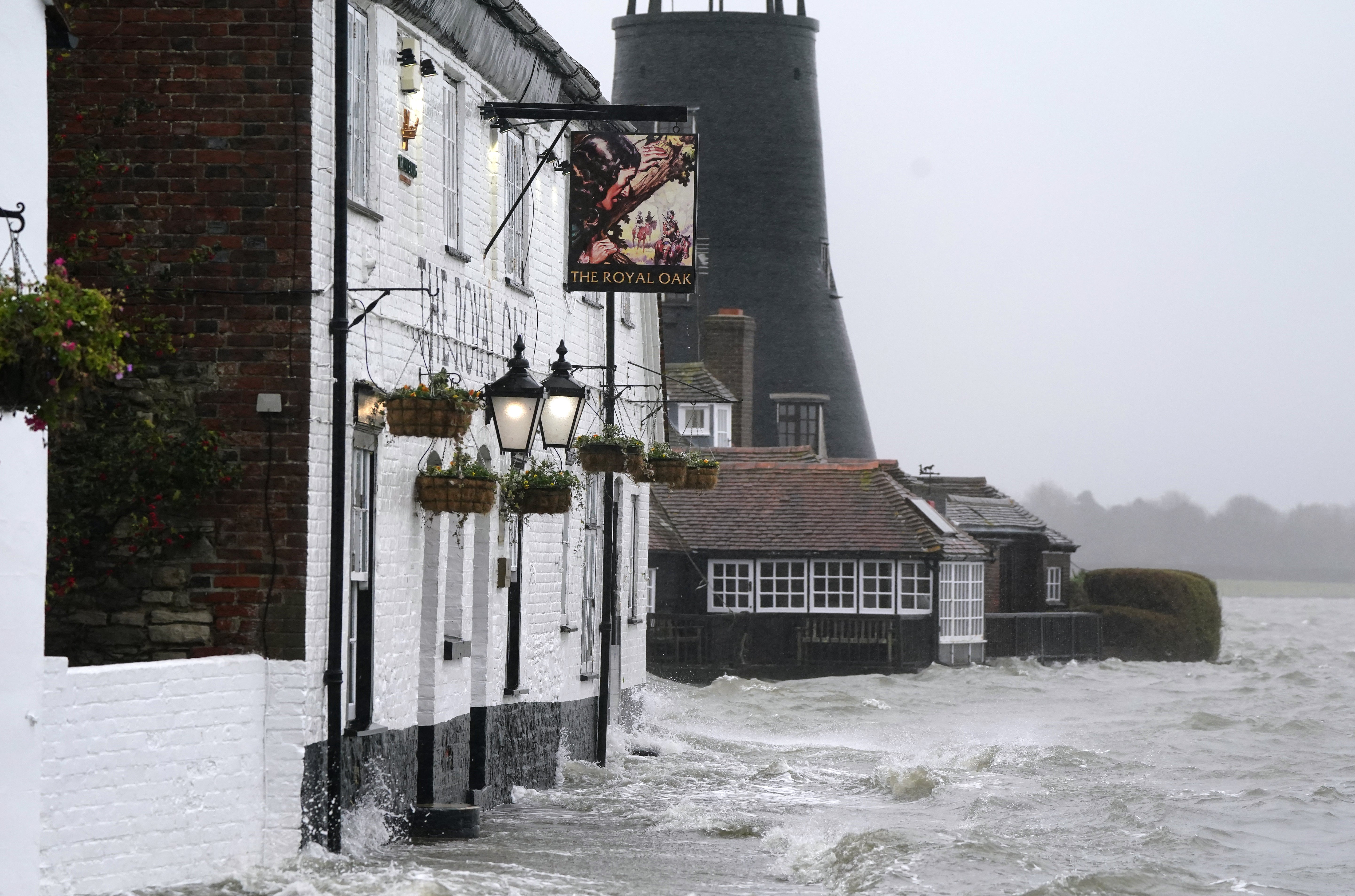 Sea water floods the shoreline outside the Royal Oak pub after high tide in Langstone, Hampshire (Andrew Matthews/PA)