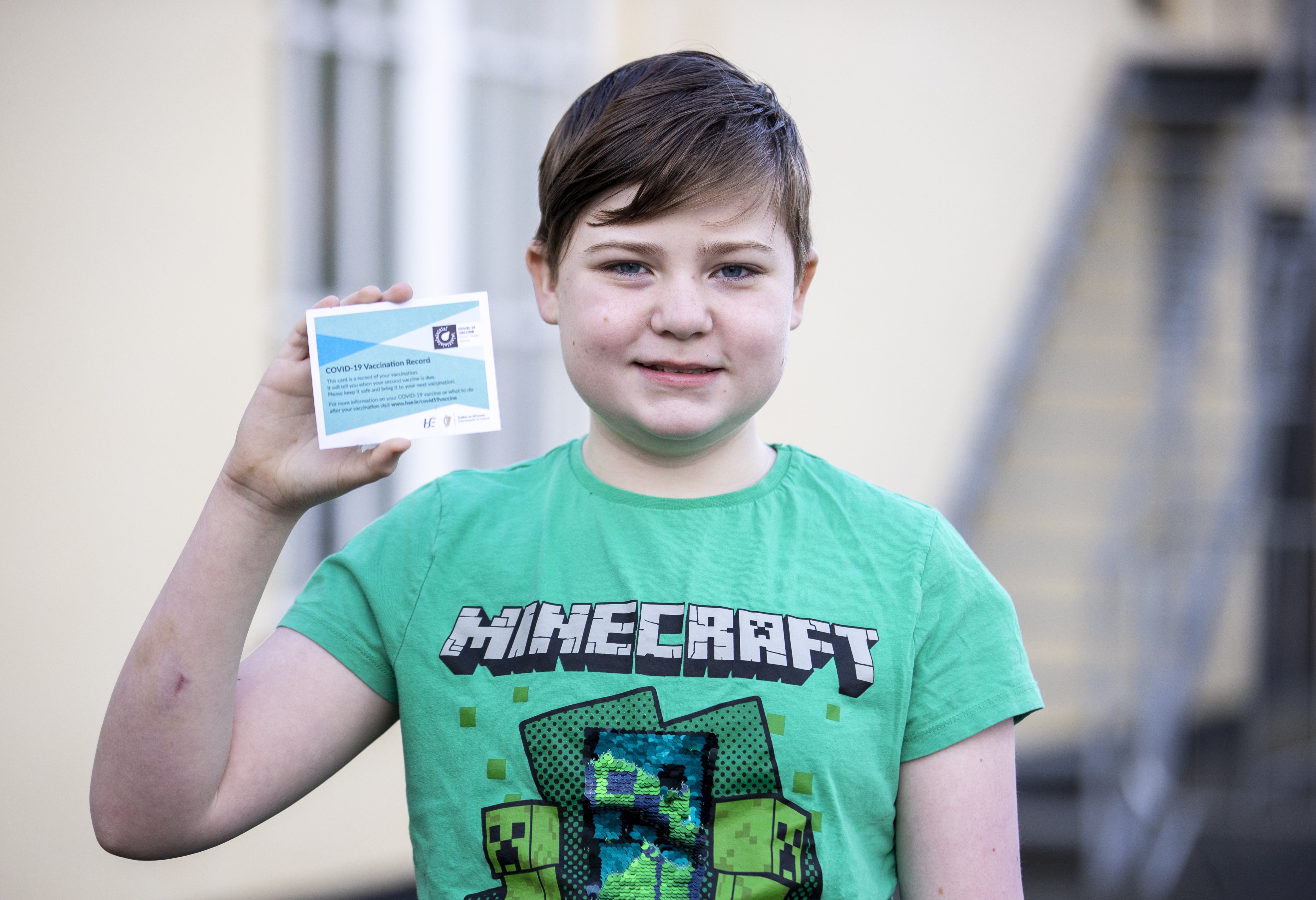 Leo McGeough, 12, with his vaccination card (Liam McBurney/PA)