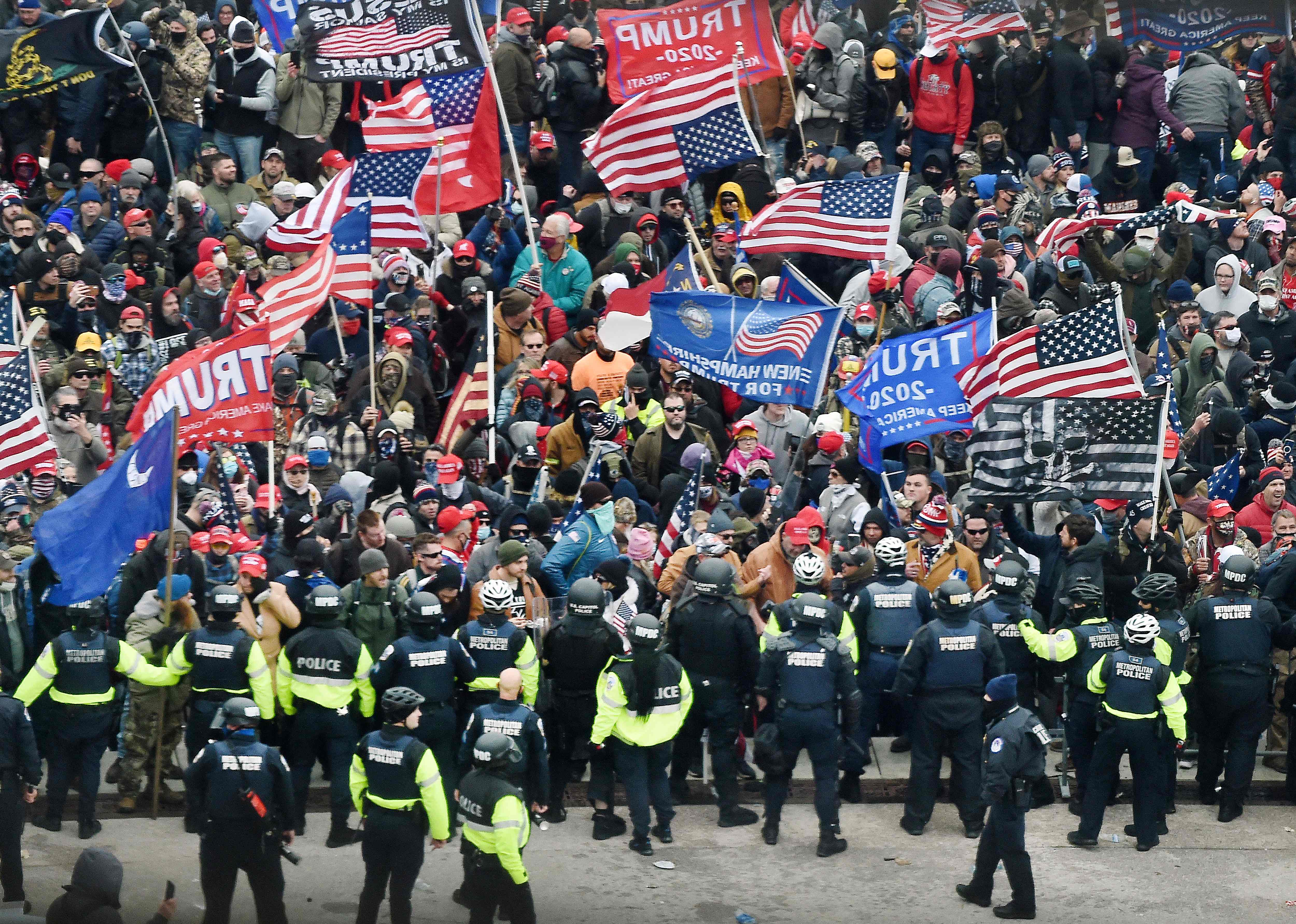 Police attempt to hold back a mob of Trump fans outside the Capitol on 6 January 2020