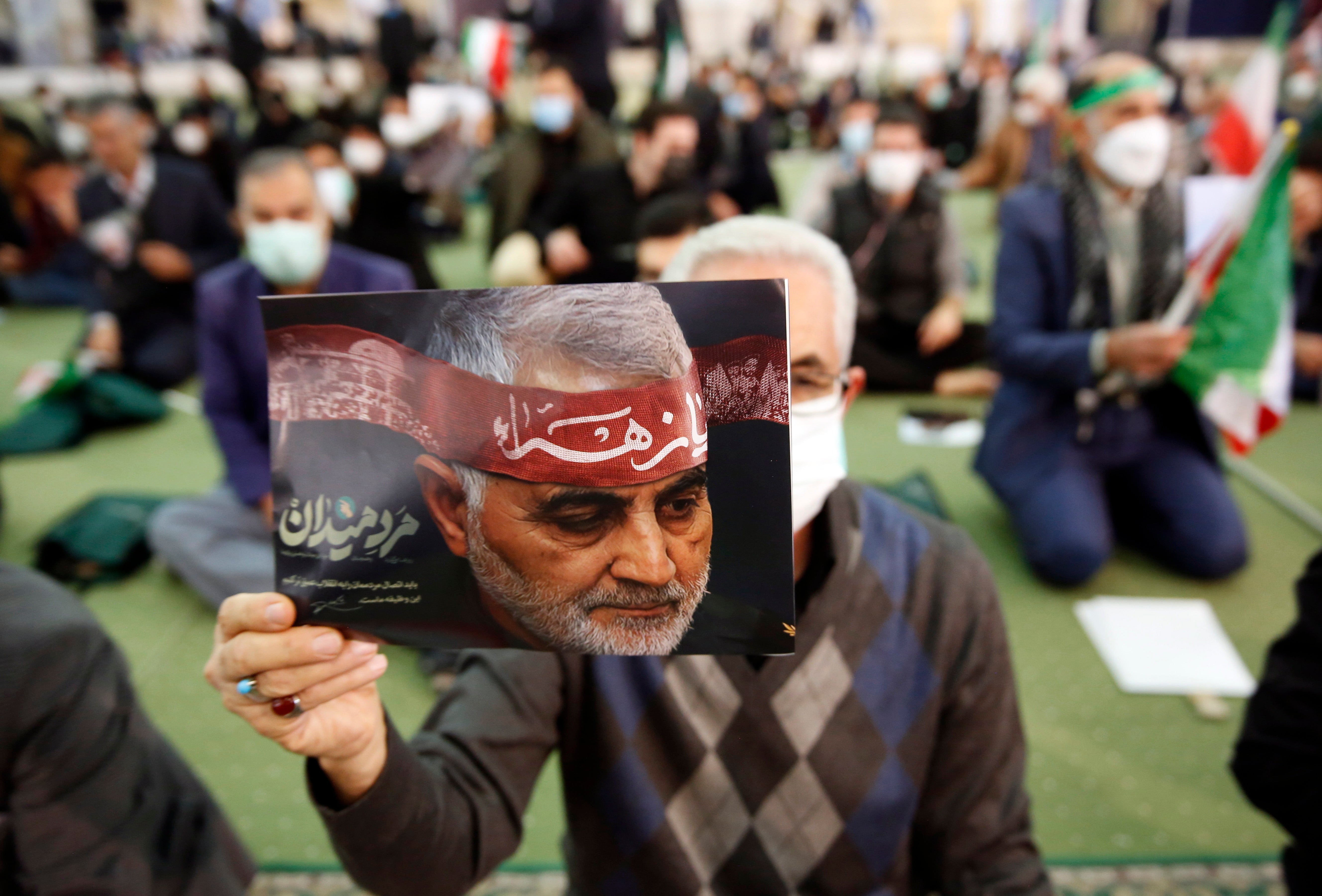 Iranians hold pictures of Qasem Soleimani during a ceremony marking the second anniversary of the death of the Iranian Revolutionary Guards Corps’ lieutenant general and commander