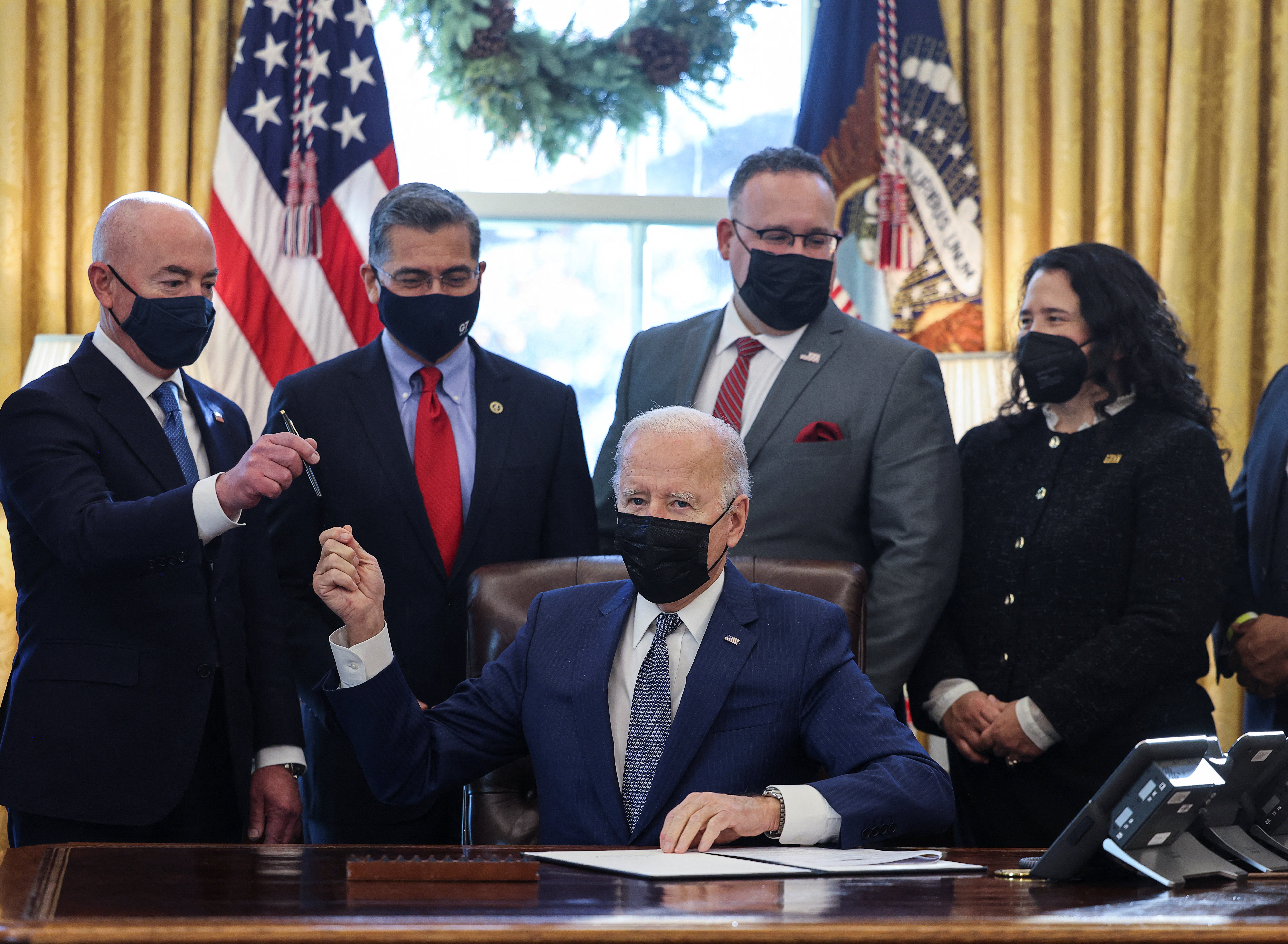 Joe Biden and Education Secretary Miguel Cardona, center right, celebrated an executive order to streamline government services – including student loan repayments – on 13 December.