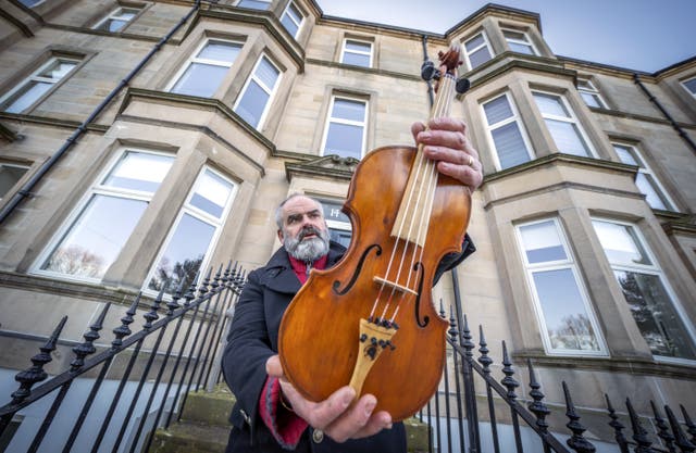 Edinburgh based luthier and nature conservationist Steve Burnett holds the Ernest Shackleton Driftwood Violin (Jane Barlow/PA)