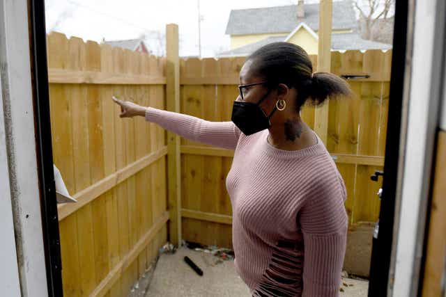 <p>Marquetta Williams shows the fence of her family home after her husband James was allegedly shot by police officers without warning on Saturday </p>