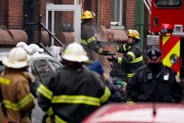 Los bomberos de Filadelfia limpian los escombros de la escena de un incendio mortal en una casa adosada, el miércoles 5 de enero de 2022, en el vecindario de Fairmount en Filadelfia.
