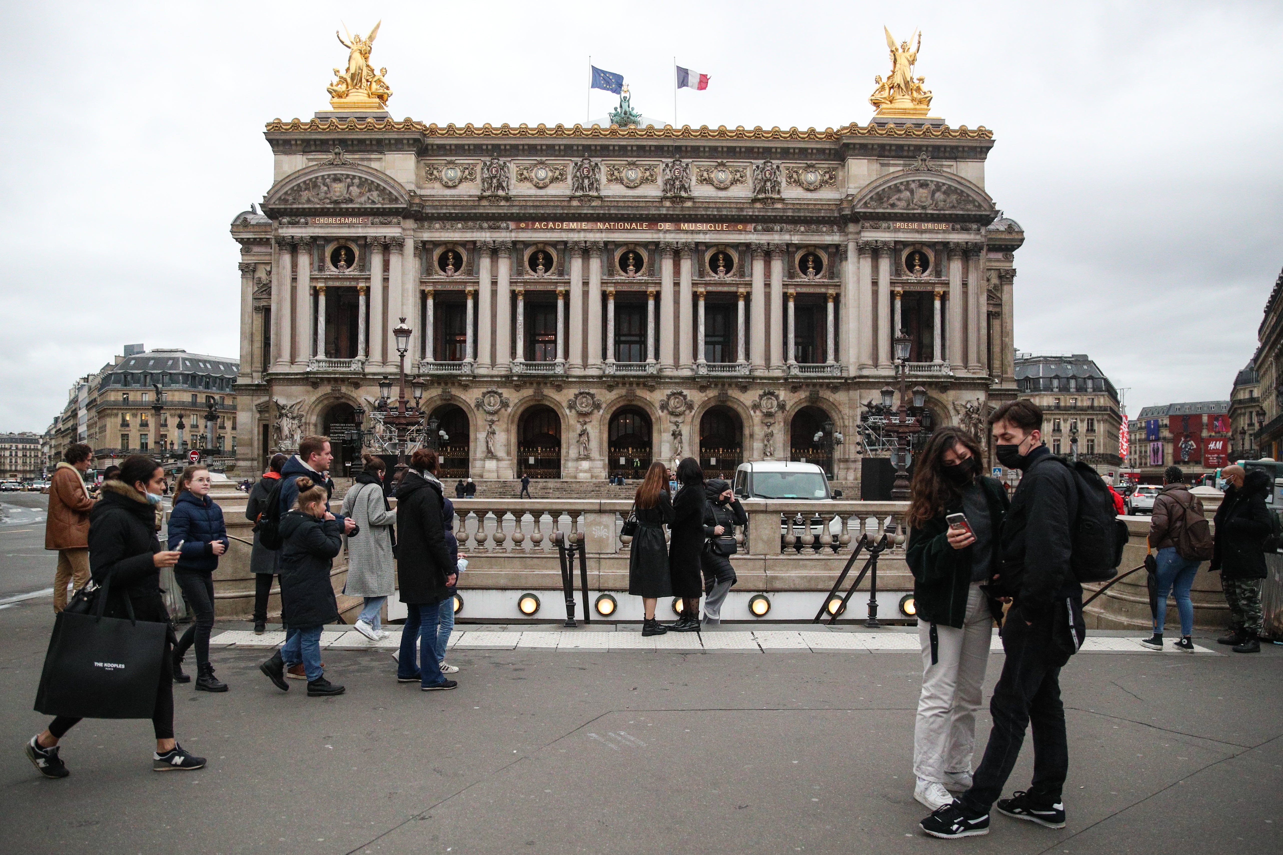 File photo: Pedestrians wearing face masks walk near the Palais Garnier opera house in Paris, France, 4 January 2022
