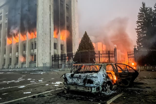 <p>A burnt car is seen by the mayors office on fire in Almaty, Kazakhstan</p>
