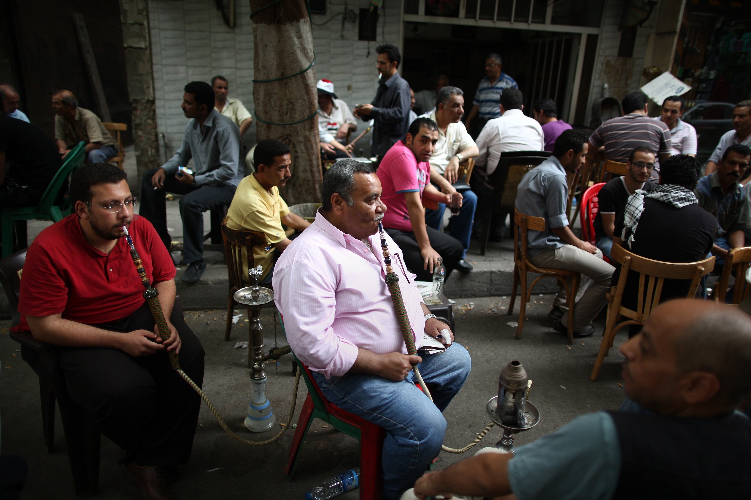 Pre-pandemic, men drink coffee and smoke shisha pipes in Cairo