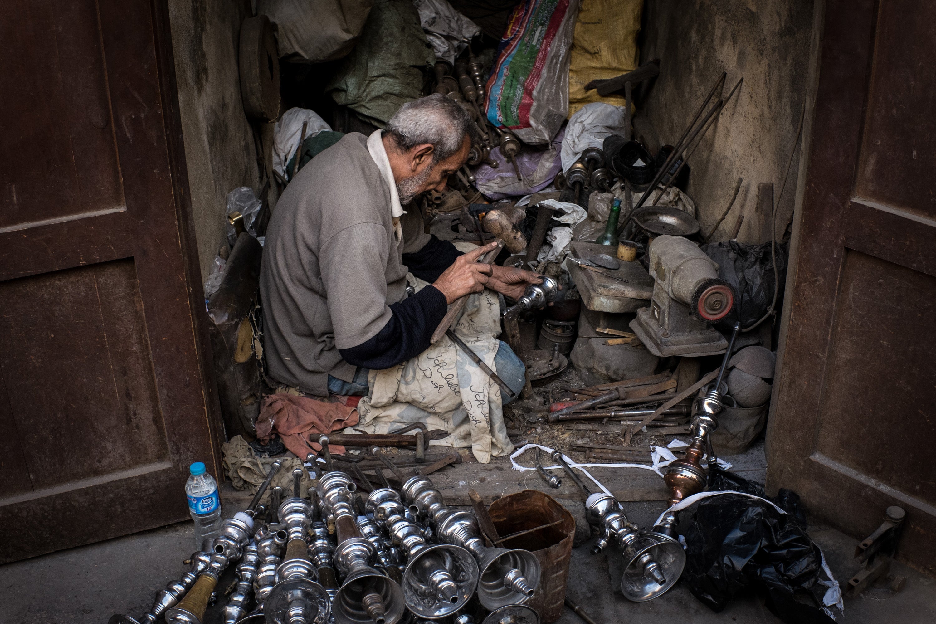 A man repairs shisha at his shop in the Old Cairo district