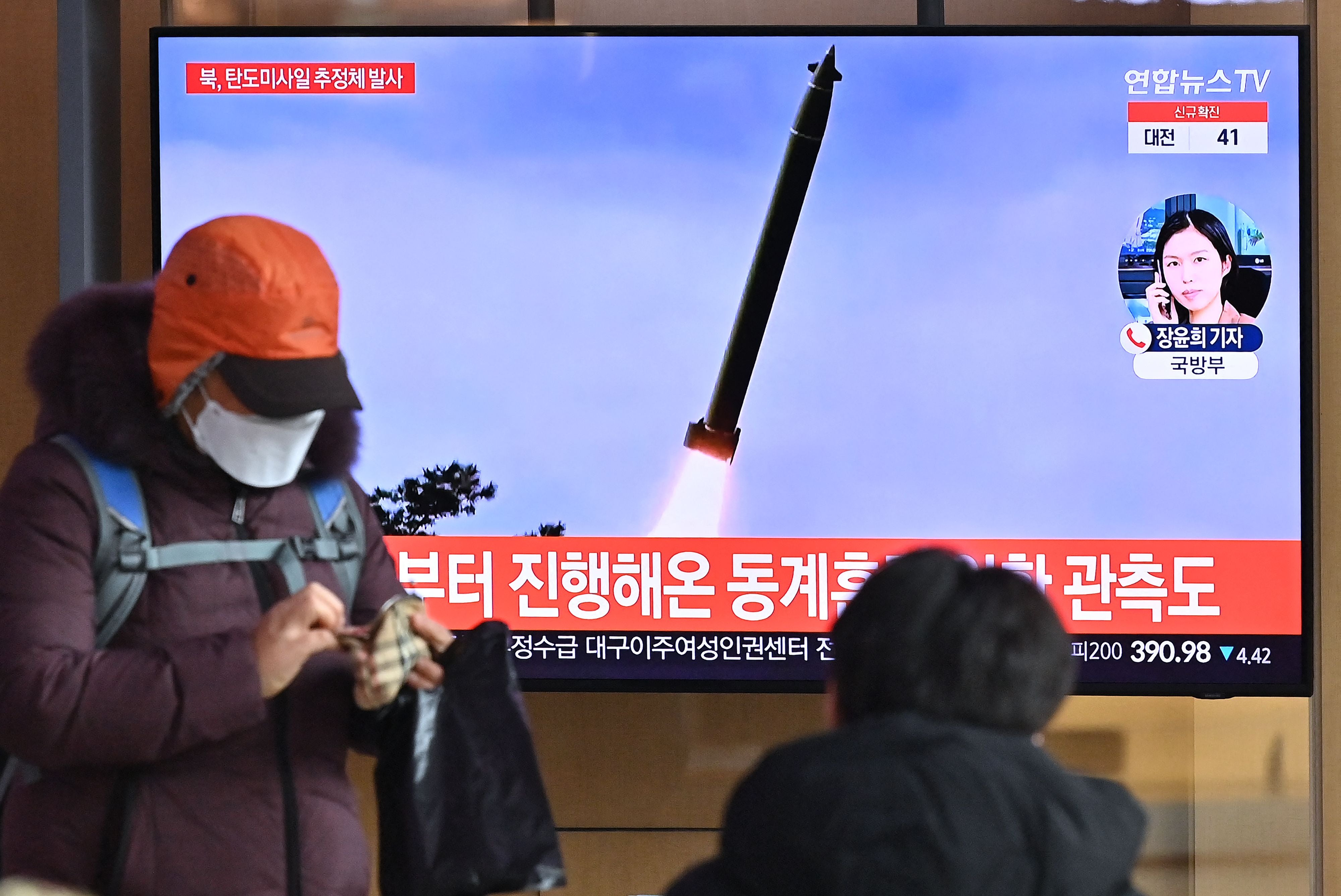 People watch a television news broadcast showing file footage of a North Korean missile test, at a railway station in Seoul