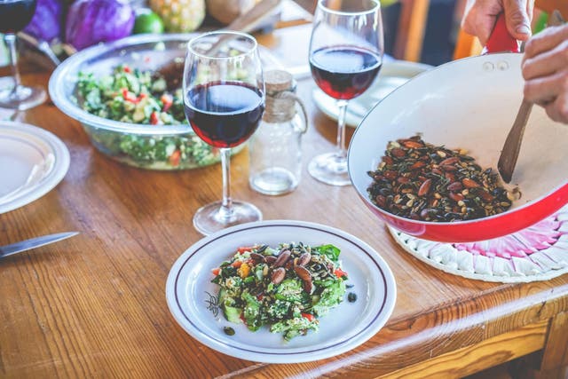 <p>Man serving organic vegan salad with wine</p>