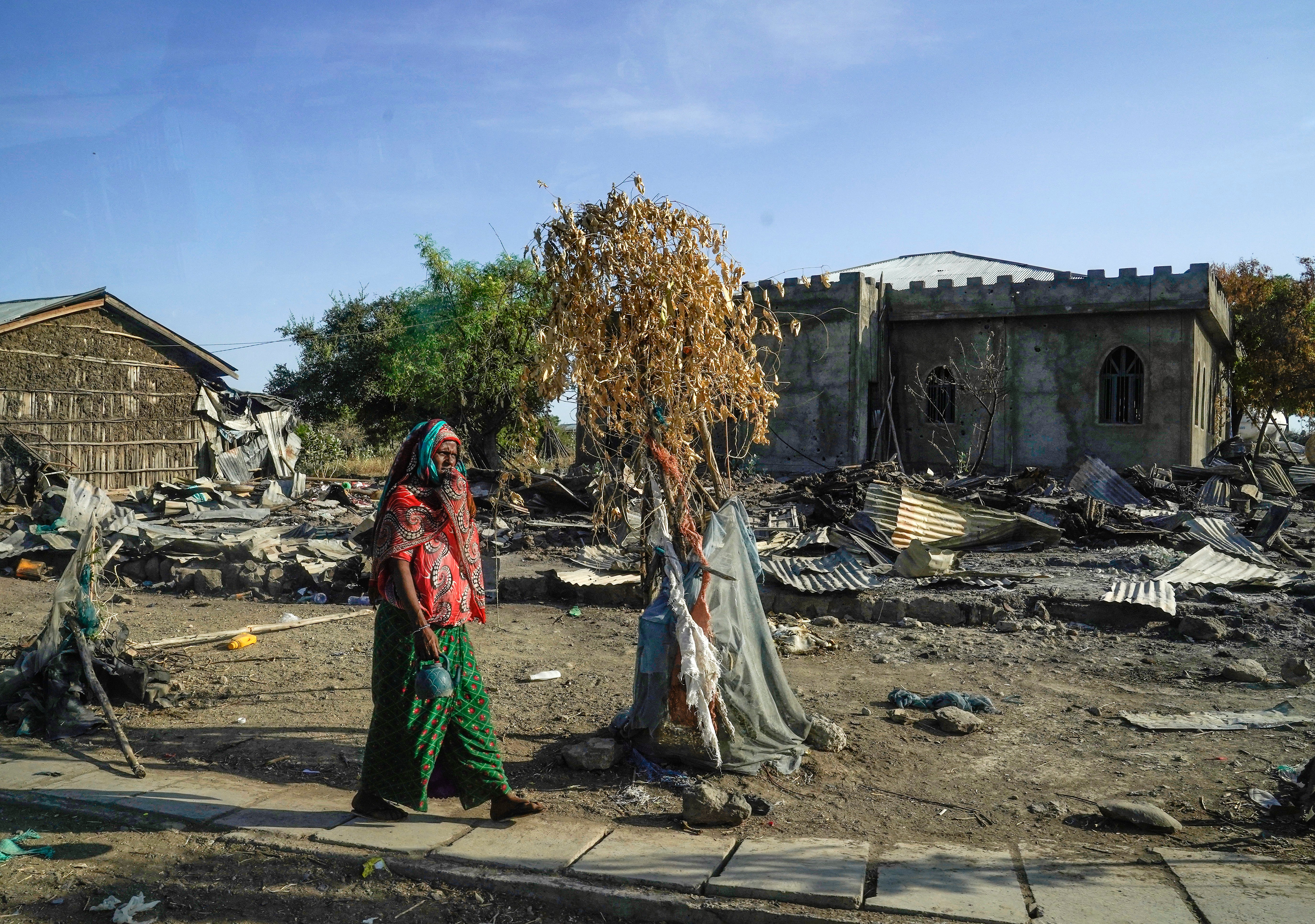 A woman walks past the mosque at Darsageta that had been heavily damaged by the Tigray People’s Liberation Front, a week ago.
