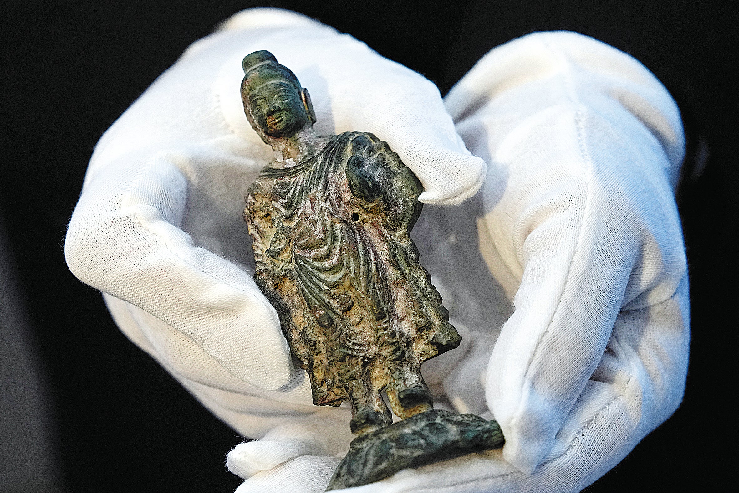 An archaeologist displays the standing statuette of the Gautama Buddha discovered in Xianyang, Shaanxi province