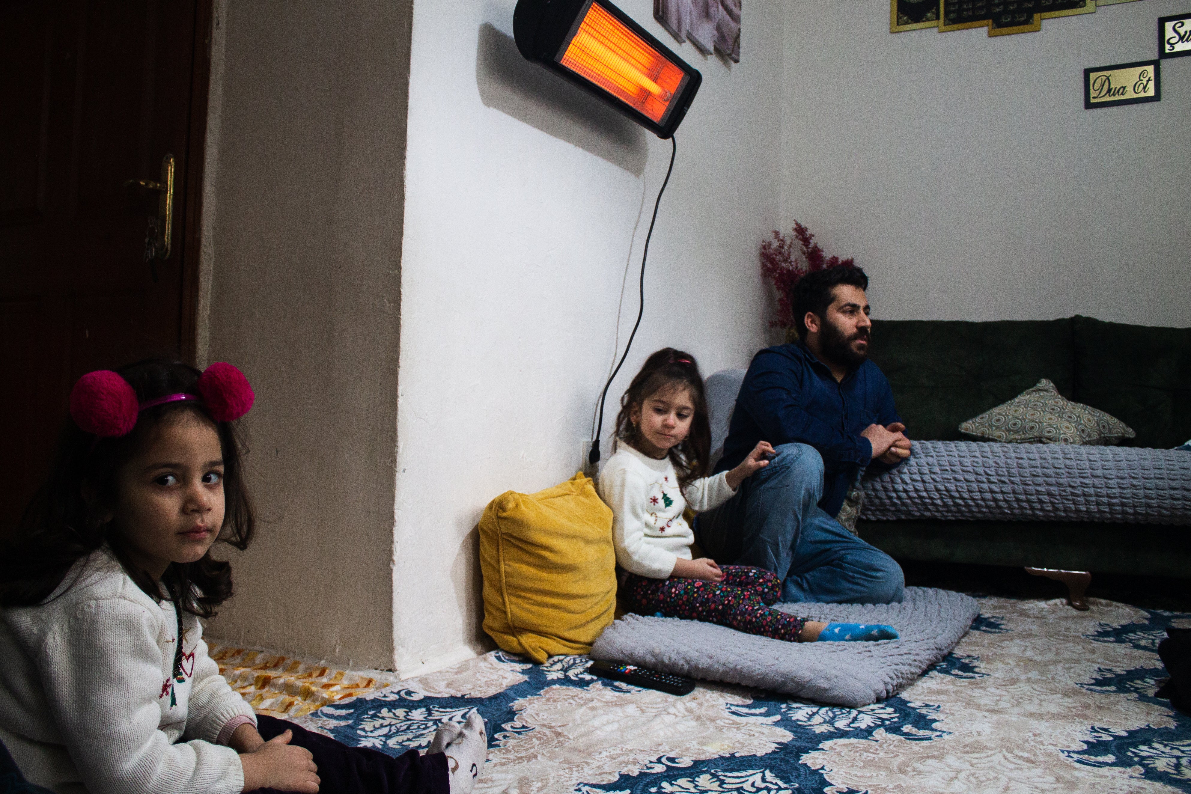 Mevlut Tekin sits with his two daughters in their rented apartment in Istanbul