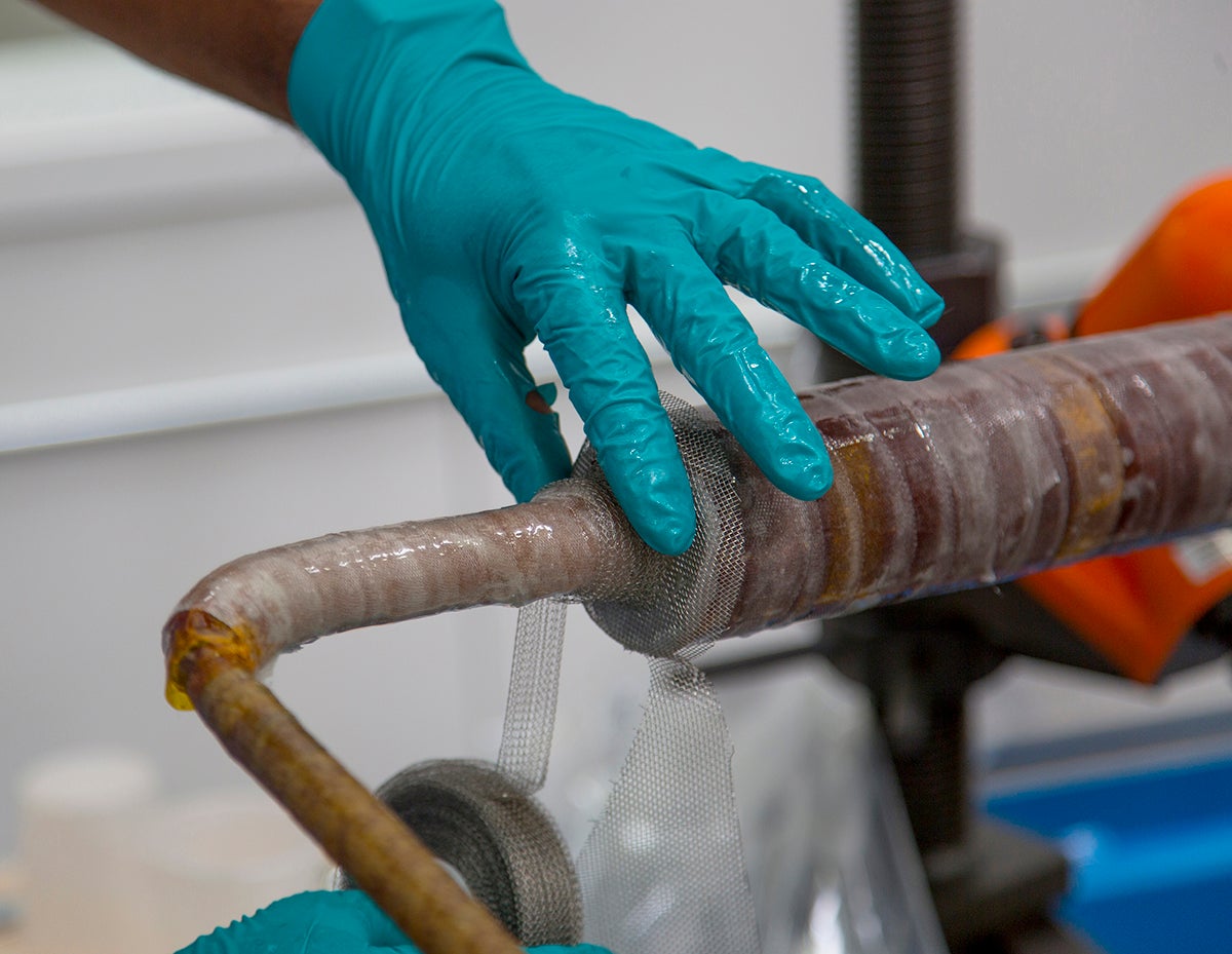 A technician insulates a component on the central solenoid by hand