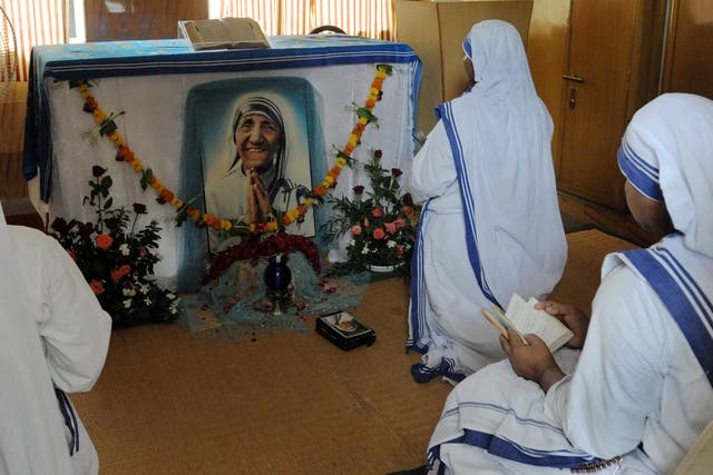 <p>Christian nuns pray in front of a photograph of Mother Teresa as they observe the fifteenth anniversary of her death </p>