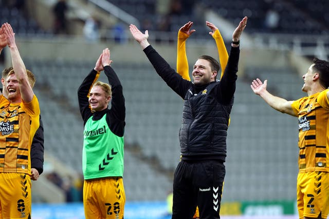 Cambridge United manager Mark Bonner (centre) celebrates with players after their shock win over Newcastle (Owen Humphreys/PA)