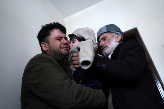 <p>Hamid Safi cries as he hands over Sohail to his grandfather Mohammad Qasem Razawi in Kabul</p>