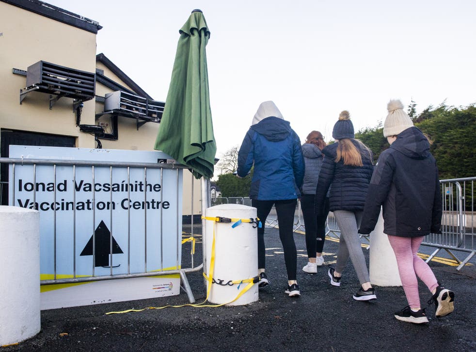 A mother takes her three daughters into the vaccination centre at The Glencarn Hotel in Castleblaney, County Monaghan (Liam McBurney/PA)