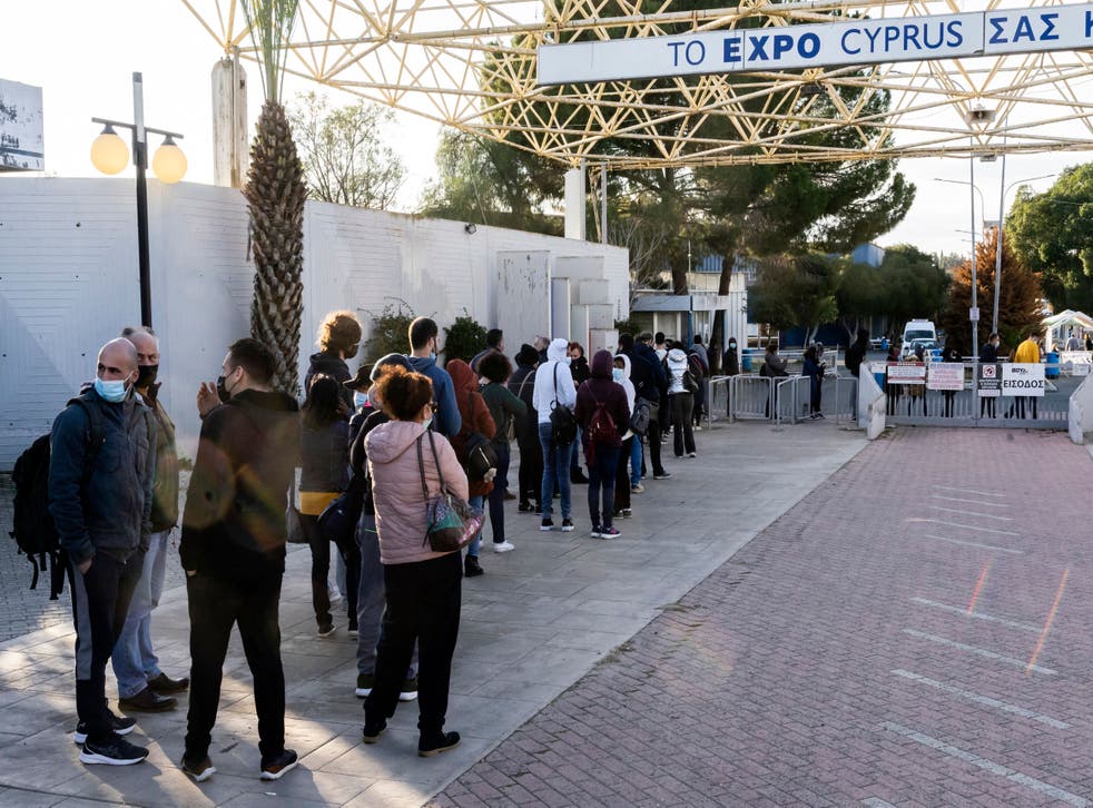 <p>Cypriots wait in line to receive the third dose of a Covid-19 vaccine at a walk-in vaccination centre in the Cypriot capital Nicosia on 4 January</p>