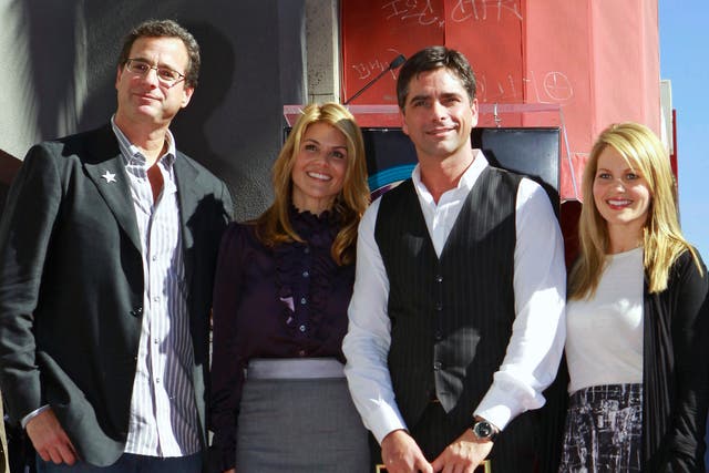 Bob Saget, left, with John Stamos, second right and former cast members from the family comedy series, Full House, Lori Laughlin and Candace Cameron Bure. Saget has died aged 65 (Damian Dovarganes/AP)