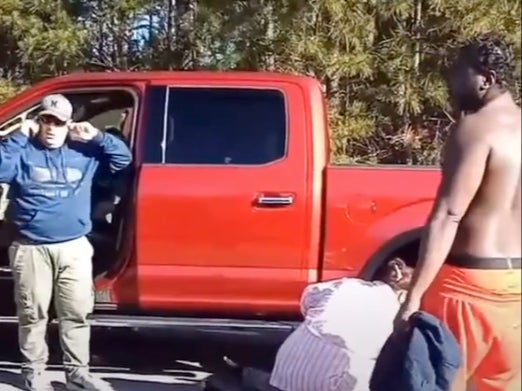 Una multitud se reúne alrededor del cuerpo de Jason Walker, que está justo fuera de la pantalla y tirado en el pavimento, después de que un ayudante del alguacil del condado de Cumberland lo matara a tiros. El ayudante, a la izquierda, está hablando con su jefe en la oficina del alguacil.