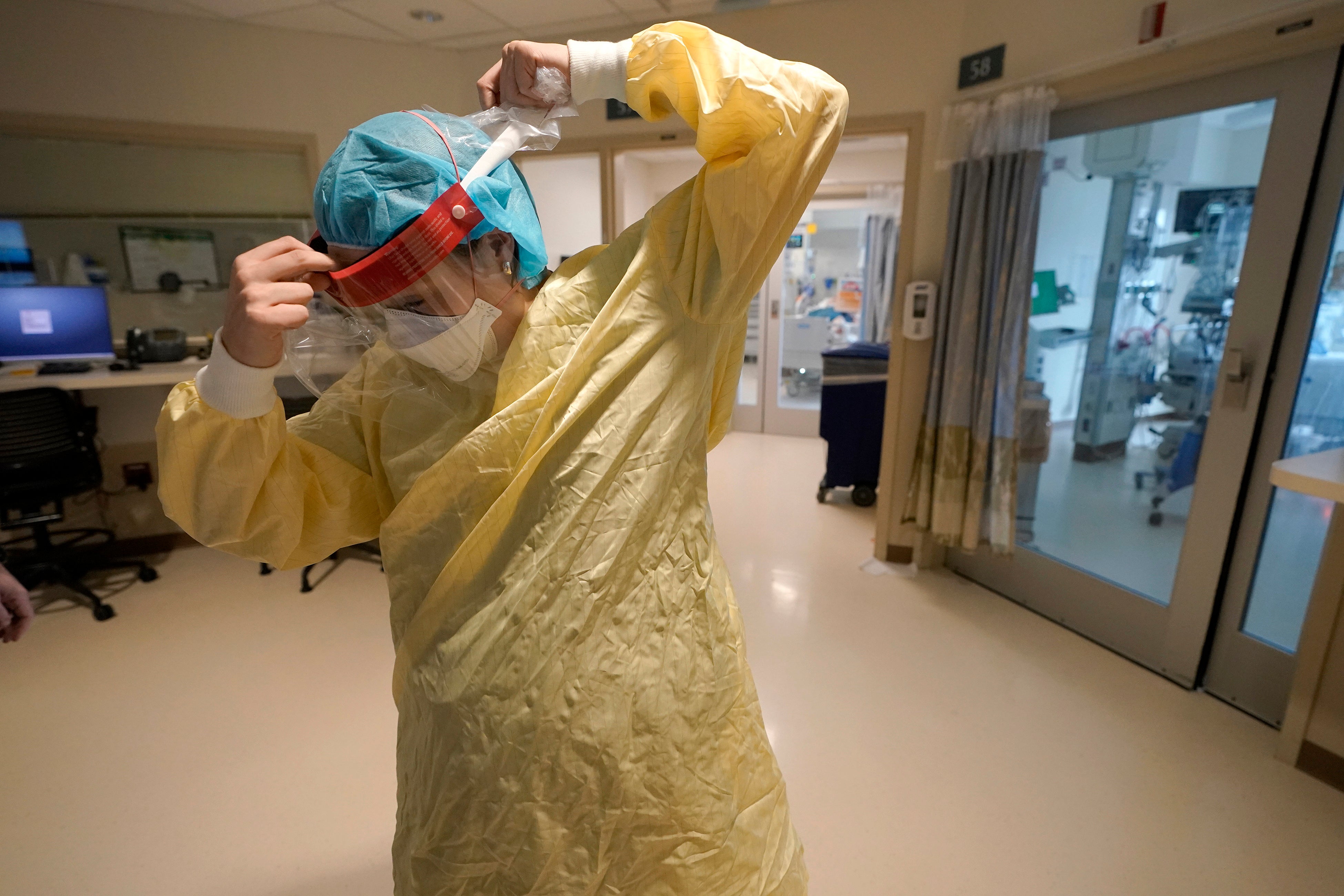 Registered nurse Sara Nystrom prepares to enter a patient’s room in the Covid-19 Intensive Care Unit at Dartmouth-Hitchcock Medical Centre, in Lebanon, New Hampshire, on 3 January 2022