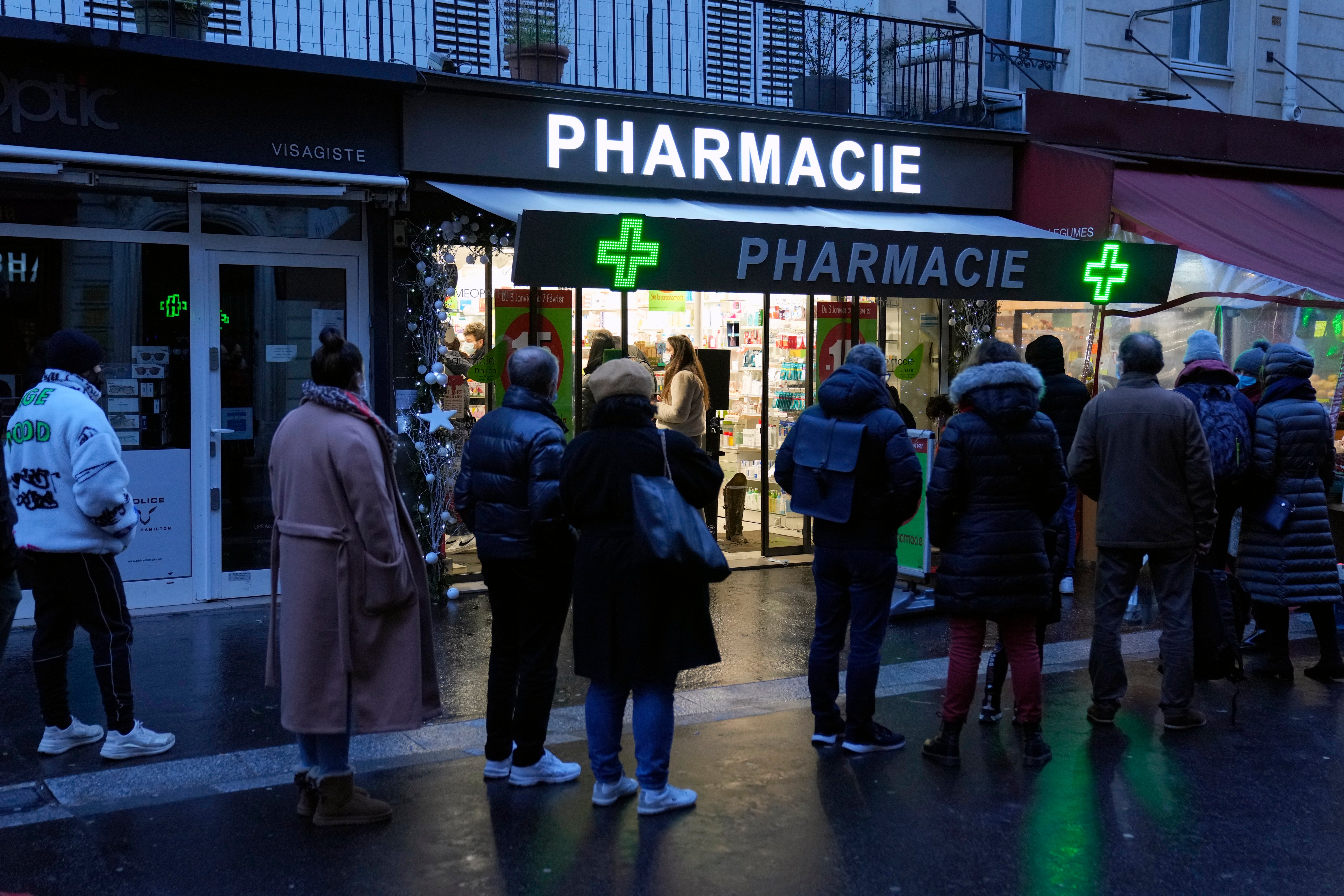 Parisians wait outside a pharmacy for Covid tests