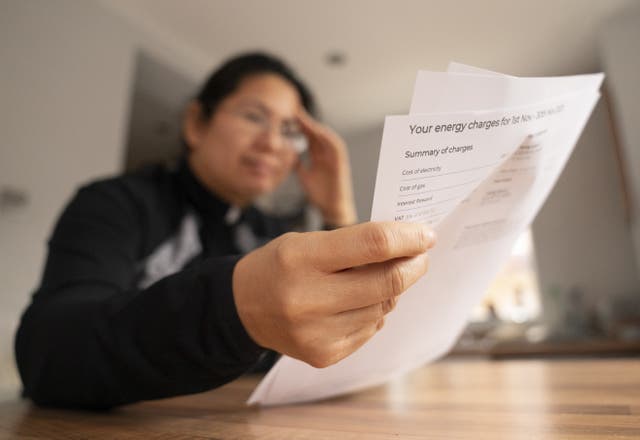 <p>A person holding an energy bill (PA)</p>