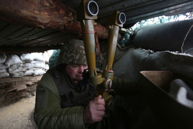 <p>A Ukrainian serviceman watches through a spyglass in a trench on the frontline with Russia-backed separatists near Lugansk village, Donetsk</p>