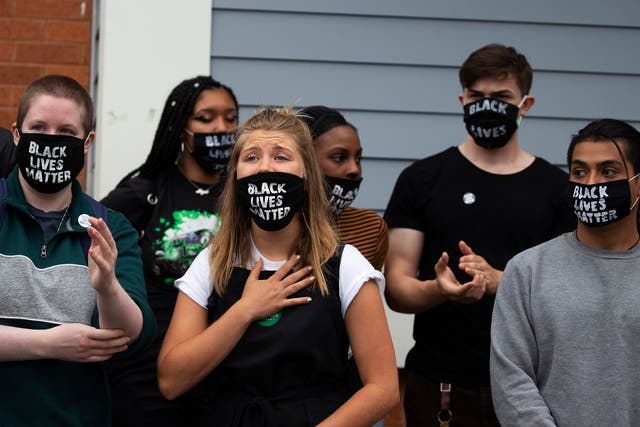 <p>Savannah Kinzer (C) reads a statement after leading a group of fellow employees in a walk out of a Whole Foods Marketplace in Cambridge, Massachusetts, USA, 30 June 2020. Last week seven employees were sent home for wearing face masks that read ‘Black Lives Matter’. Employees were told by management that the masks did not comply with the company dress code and were asked to wear other masks or leave work. A group of employees released a statement that demanded that Whole Foods ‘to join the anti-racist, Black Lives Matter movement’.  EPA/CJ GUNTHER</p>