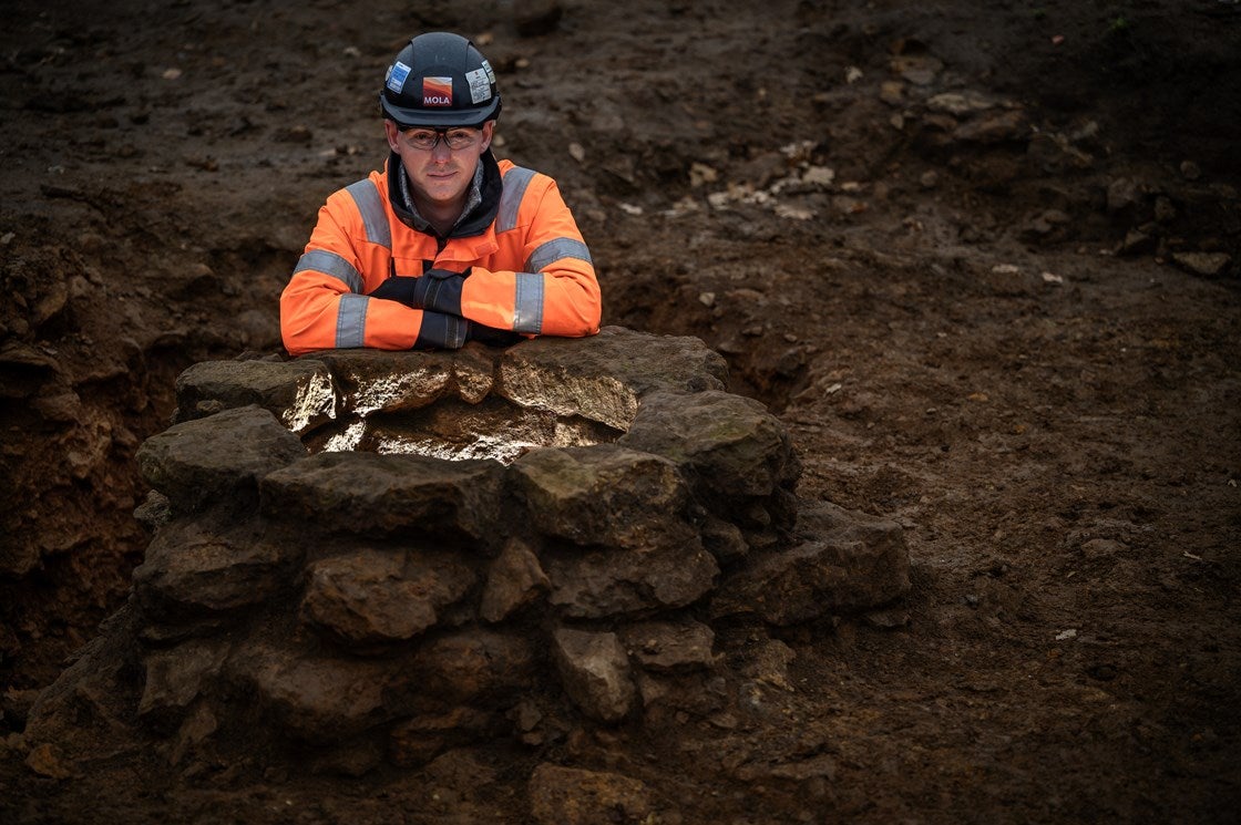 An archaeologist with a Roman well discovered at Blackgrounds