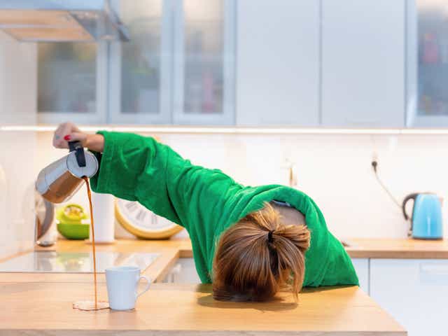 <p>A tired woman pours coffee, misses the cup</p>