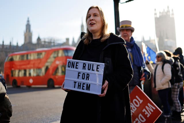 <p>Demonstrators hold placards as they protest near the House of Commons on Wednesday </p>