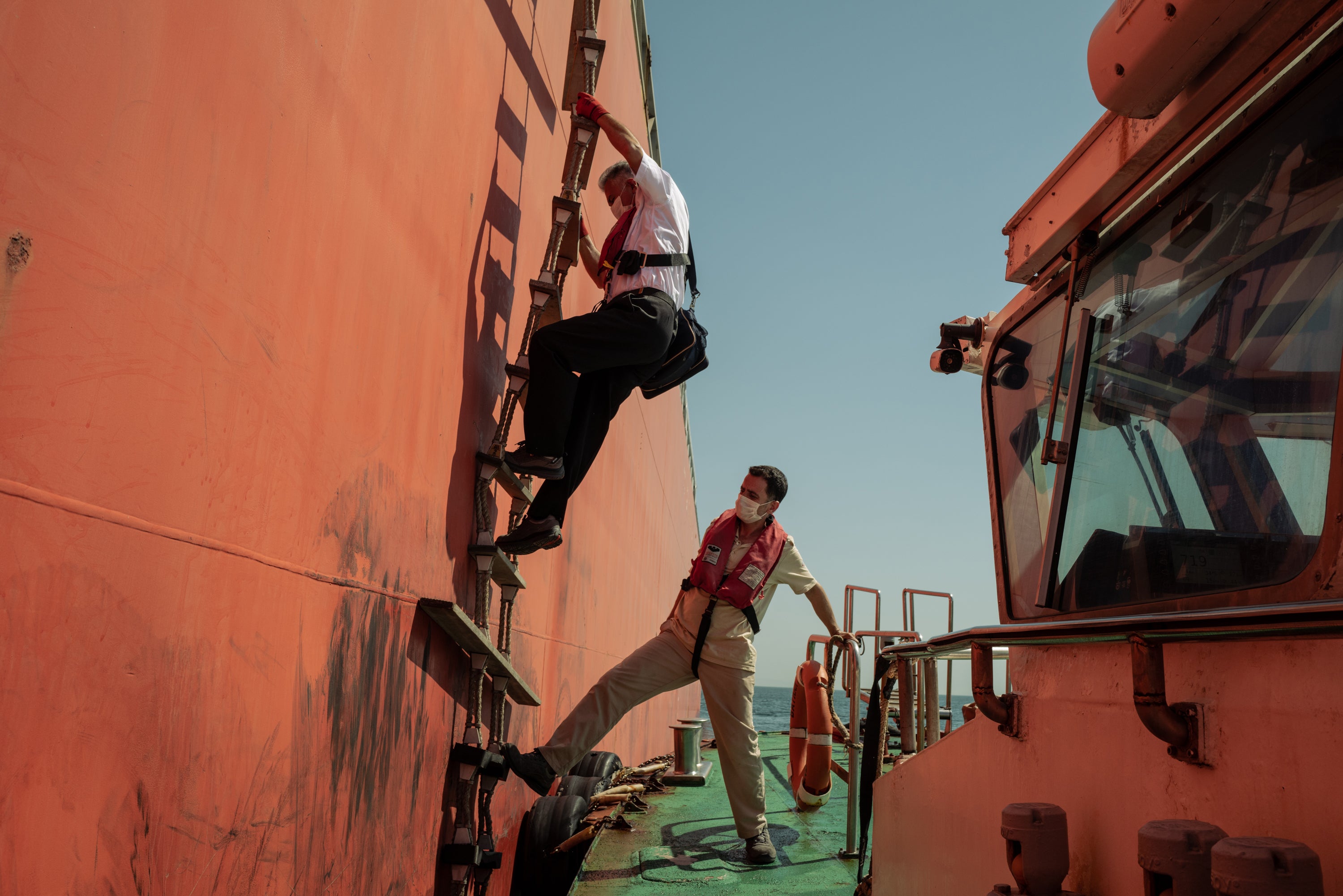 Ismail Akpinar climbs down the rope-and-wood ladder after helping the Gas Grouper through the straits